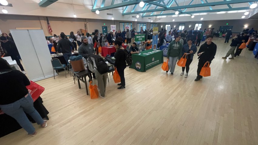 People standing around tables in a big room.