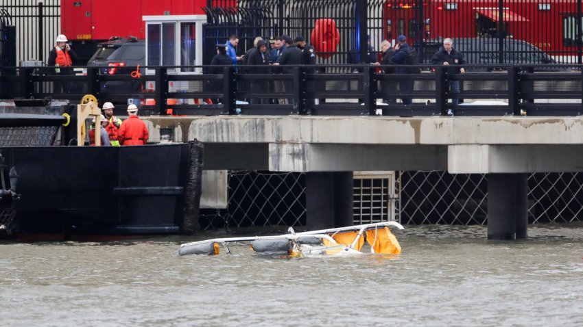 First responders are seen near the landing skids of a helicopter after it crashed into the Hudson River, in Newport, New Jersey, on April 10, 2025. A helicopter crashed into the Hudson River in New York on Thursday, emergency services said, as local media reported multiple deaths in the incident. Several people were pulled from the water and taken to a hospital in New Jersey, the NBC4 broadcaster reported citing law enforcement at the scene, adding that four had died. (Photo by Leonardo Munoz / AFP) (Photo by LEONARDO MUNOZ/AFP via Getty Images)