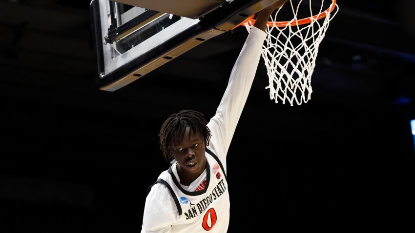Mar 18, 2025; Dayton, OH, USA; San Diego State Aztecs forward Magoon Gwath (0) hangs from the basket in the first half against the North Carolina Tar Heels at UD Arena. Mandatory Credit: Rick Osentoski-Imagn Images