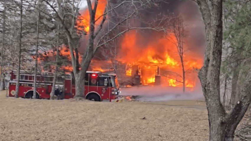 Firefighters work near a building engulfed in fire following a plane crash in Brooklyn Park, Minnesota on March 30, 2025.